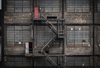 Weathered brick industrial building facade with metal fire escape