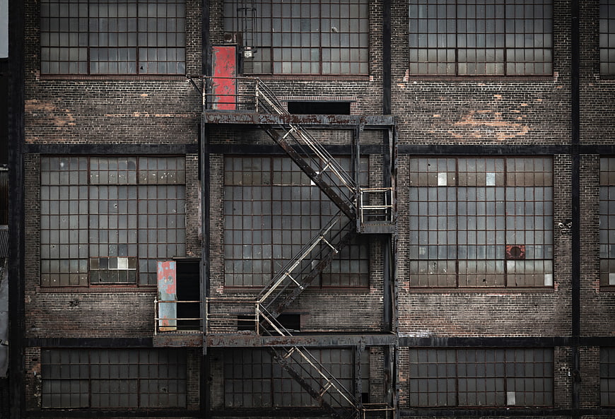 Weathered brick industrial building facade with metal fire escape