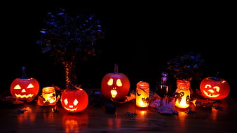 Glowing Halloween Jack-o'-Lanterns and Candles on Dark Wooden Table