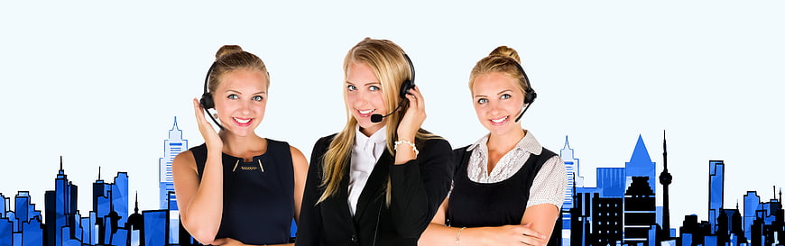 Three female call center agents with headsets against city skyline