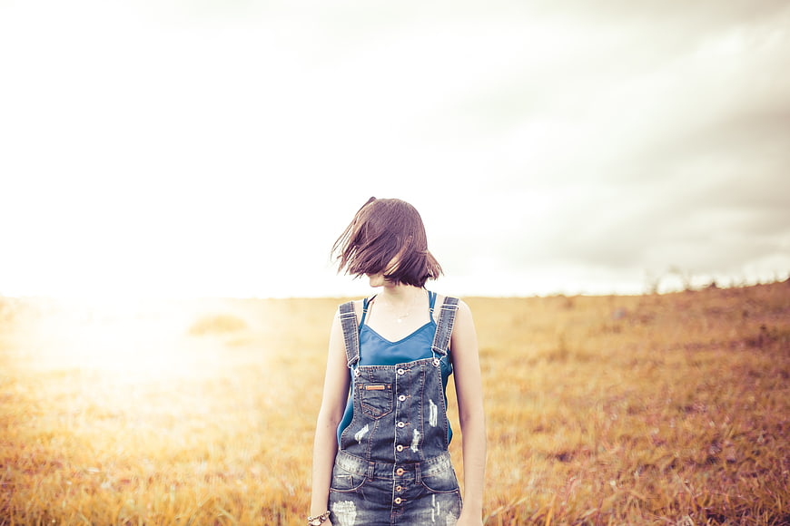 Woman in Denim Overalls Standing in Golden Autumn Field