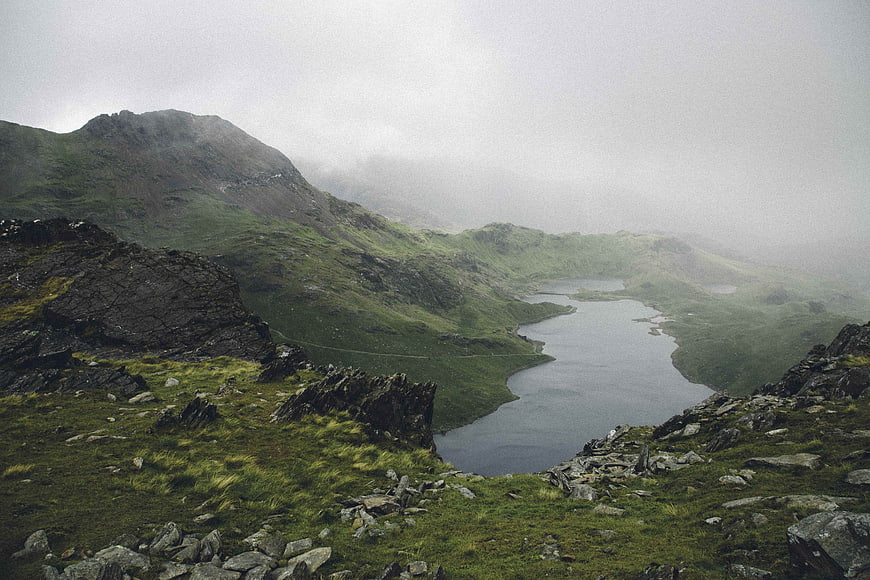 Misty Mountain Lake Landscape with Green Hills and Rocks