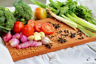Fresh Vegetables and Spices Arranged on a Wooden Cutting Board
