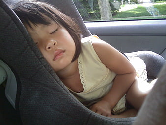 Toddler Girl Sleeping Peacefully In Car Seat During Road Trip