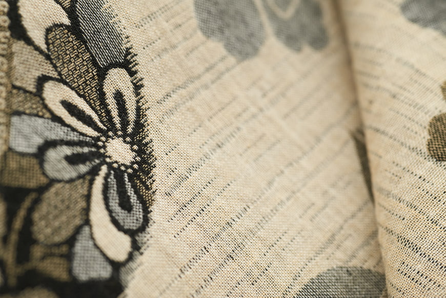 Close-up of beige woven fabric with floral pattern