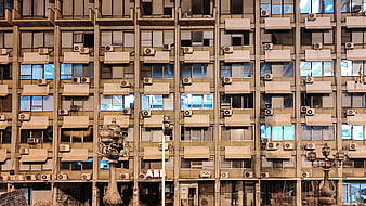 Urban apartment building facade with air conditioners and windows