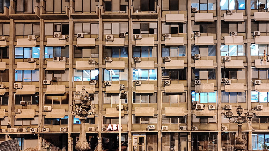 Urban apartment building facade with air conditioners and windows