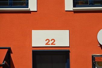 Orange building facade with white house number 22