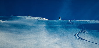 Snowboarder carving fresh powder on a vast blue mountain slope