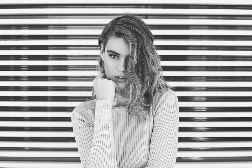Black and white portrait of woman against striped background