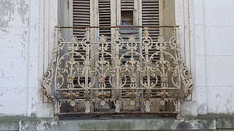 Vintage ornate wrought iron balcony railing on old facade