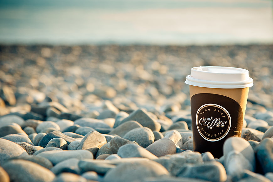 Coffee Cup on Pebble Beach at Sunrise