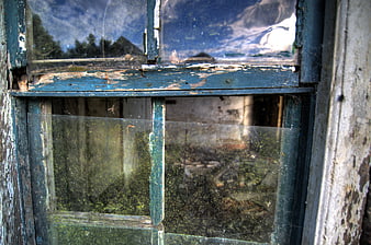 Close-up of weathered blue window frame with peeling paint