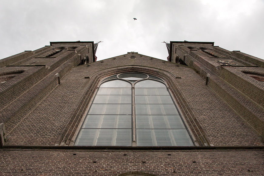Low angle view of brick church facade with large arched window