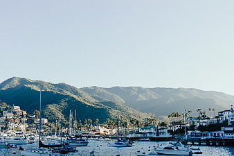 Sailboats in Harbor with Mountains and Coastal Town