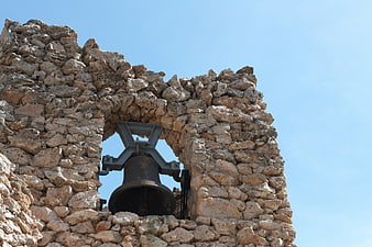 Old stone bell tower against blue sky