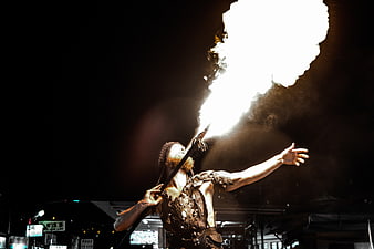 Male Fire Breather Performing at Night with Dramatic Flames