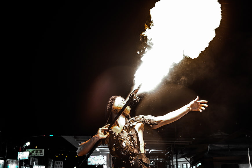 Male Fire Breather Performing at Night with Dramatic Flames