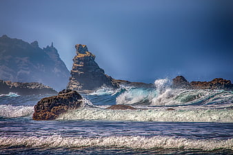 Dramatic Ocean Waves Crashing Against Rugged Rock Formation