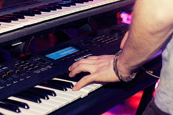Close-up of hands playing Kurzweil electronic keyboard