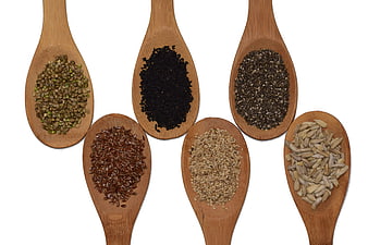 Assorted Seeds on Wooden Spoons Isolated on White Background