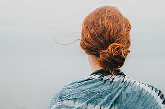 Back view of woman with red hair bun looking out