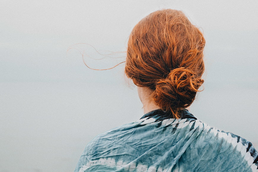 Back view of woman with red hair bun looking out