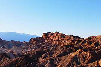 Sunlit desert mountains with blue sky background