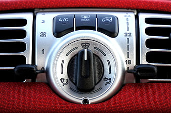 Close-up of car climate control panel with A/C and rear defrost buttons