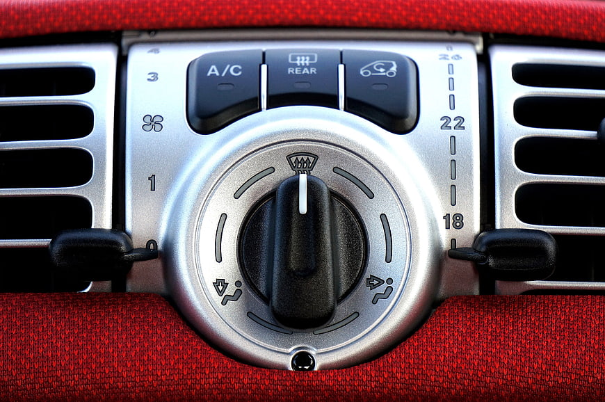 Close-up of car climate control panel with A/C and rear defrost buttons
