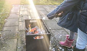 Children roasting marshmallows over outdoor fire pit