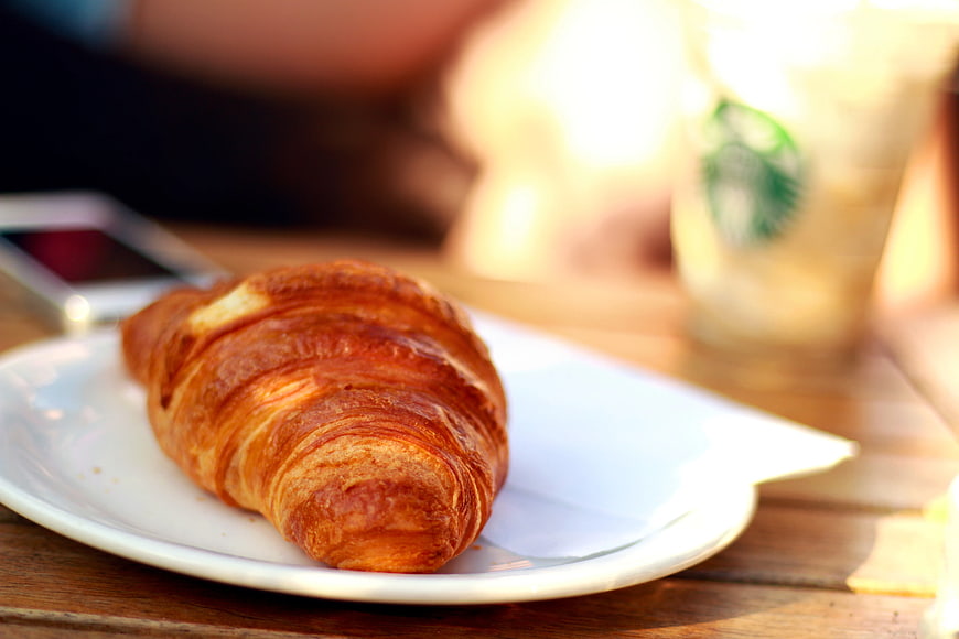 Golden Croissant on White Plate with Coffee