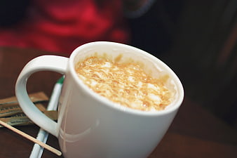 Close-up of frothy coffee in a white ceramic mug