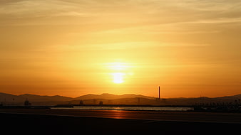 Golden Sunset Over Harbor With Silhouetted Mountains