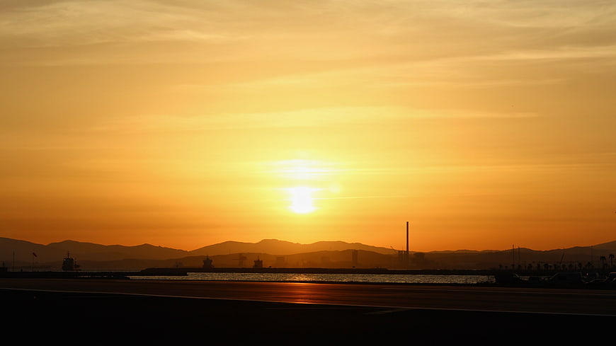 Golden Sunset Over Harbor With Silhouetted Mountains