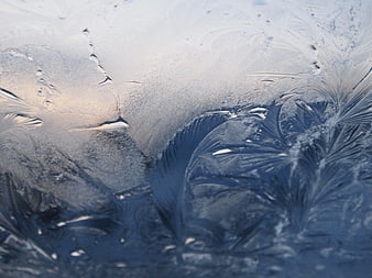 Closeup of intricate frost patterns on a cold window pane