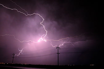 Dramatic Purple Lightning Strike Over Rural Power Lines at Night
