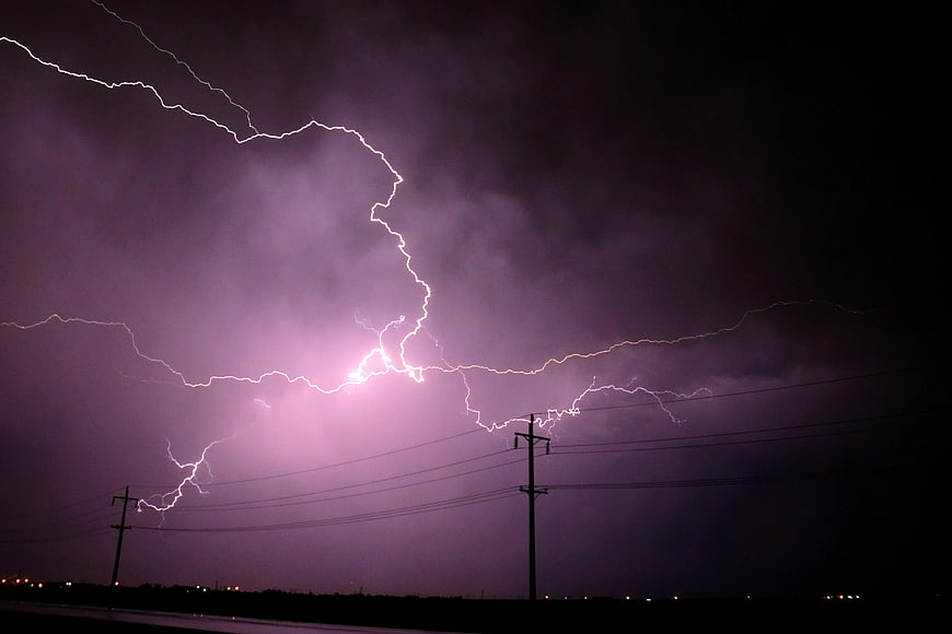 Dramatic Purple Lightning Strike Over Rural Power Lines at Night