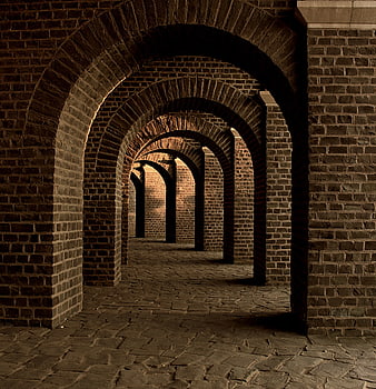 Dark brick archway corridor with stone floor