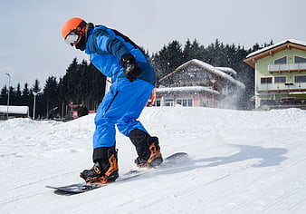 Snowboarder in Blue Suit Carving on Groomed Slope