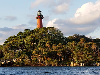 Red Lighthouse on Lush Green Island at Sunset