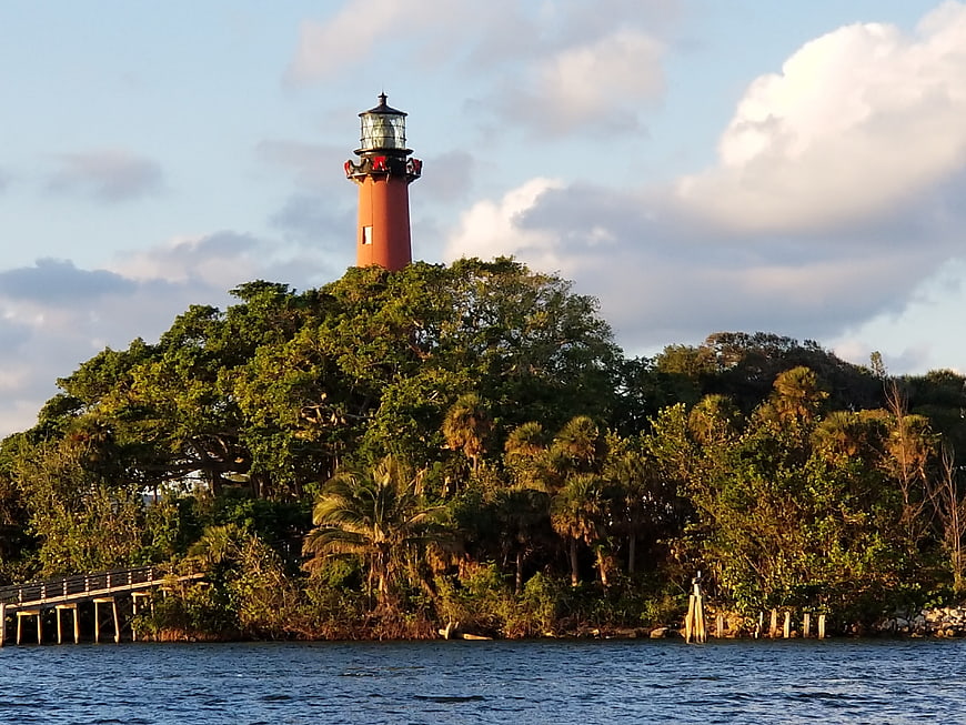 Red Lighthouse on Lush Green Island at Sunset
