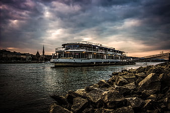Dramatic River Cruise Ship at Dusk with Rocky Foreground