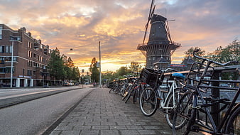 Amsterdam Canal Sunset With Windmill And Parked Bicycles