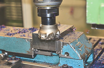 Close-up of CNC milling cutter machining metal workpiece with shavings