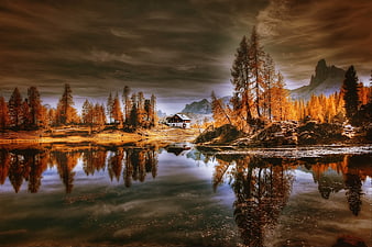 Dramatic Autumn Cabin Reflection in Dolomites Lake