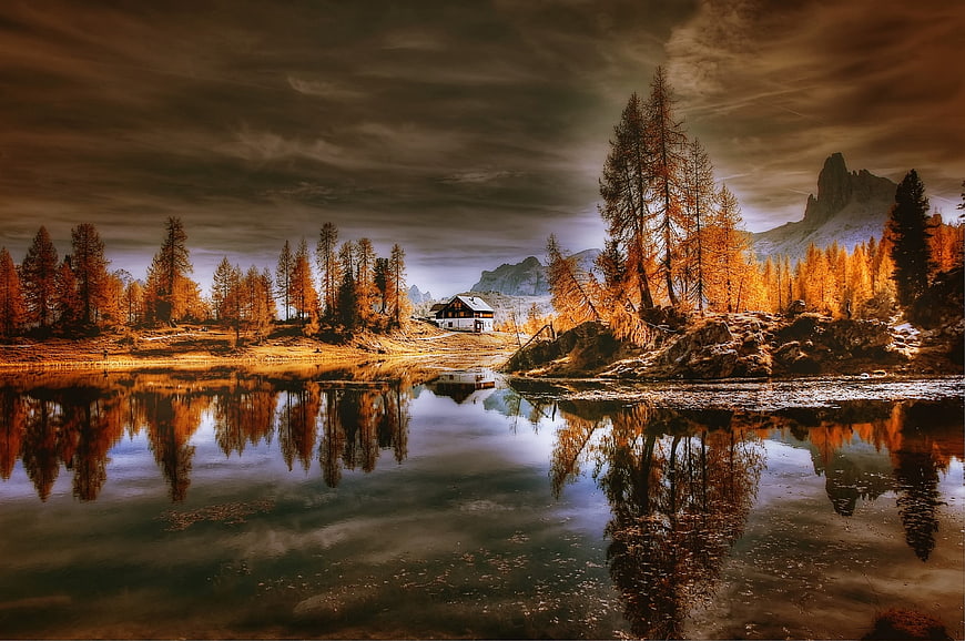 Dramatic Autumn Cabin Reflection in Dolomites Lake