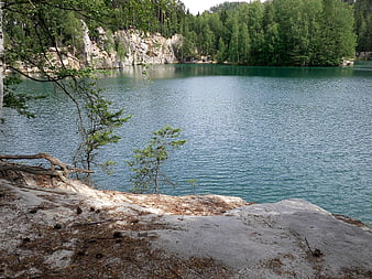 Serene turquoise lake surrounded by forest and rocky cliffs