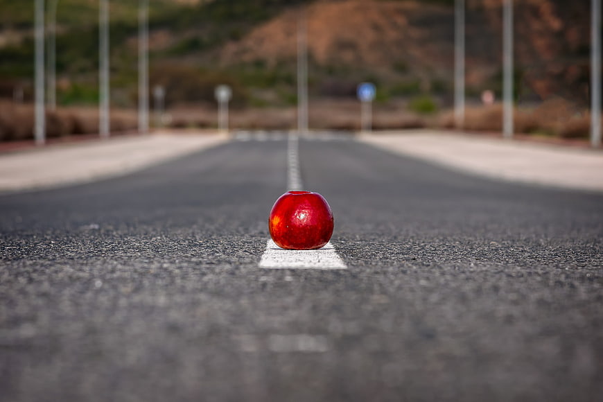 Red Apple on Asphalt Road Center Line