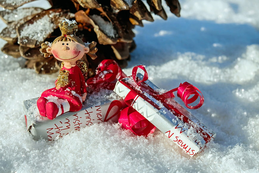 Christmas Angel Doll Sitting on Gift Box in Snow
